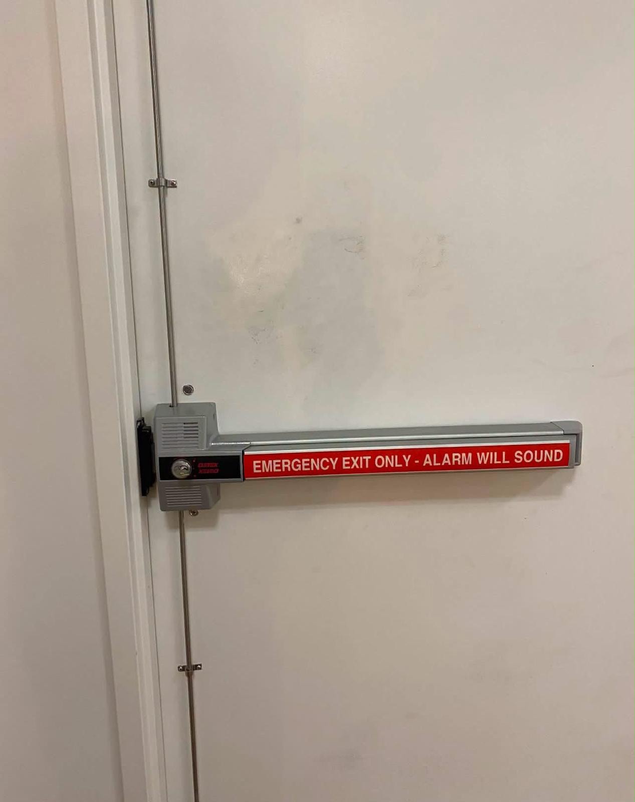 Emergency exit door with alarm push-bar hardware.